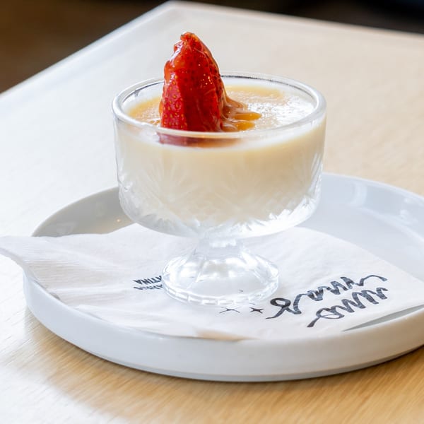 El Barrio's creamy dessert in a glass, topped with a fresh strawberry and caramel drizzle.